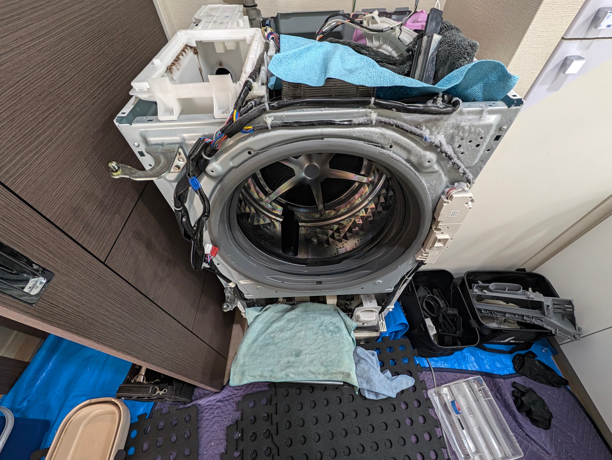 前面を分解した洗濯機本体と周辺のホコリ